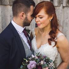 Red head bride holds bouquet and husband