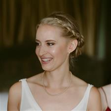 Blonde bride with braided hair smiles off camera