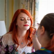 Bride with bright red hair gets her bright red lipstick applied by me