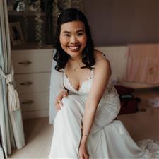 Bride smiles at camera putting on her shoes