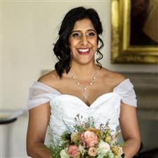 Nupur stands in her white dress holding her bouquet