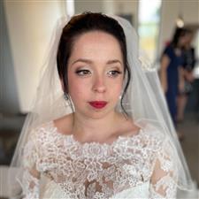 Soft vintage makeup on bride with white dress and veil, wearing red lipstain