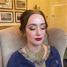 Full glam vintage styled makeup with red lips, shimmery gold eyeshadow and black eyeliner flicks